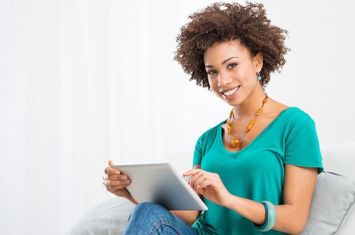 african american woman smiling holding ipad